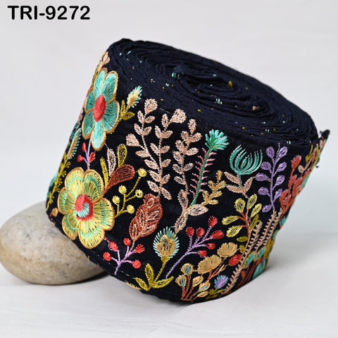 a close-up view of a black fabric with a colorful floral embroidered design.