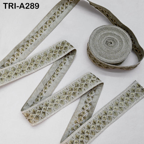 a collection of decorative fabric pieces, including a spool of thread with a repeating pattern and several pieces of fabric with a similar pattern.