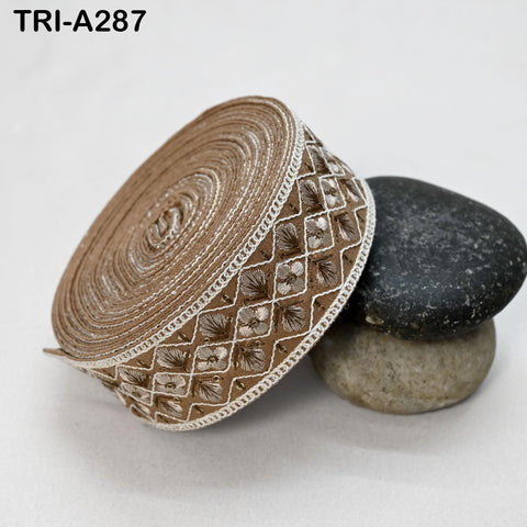 a close-up view of a decorative fabric with a floral pattern, resting on a surface with two rocks.
