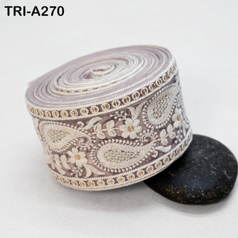 a decorative fabric with a floral pattern, placed on a black surface next to a small black rock.