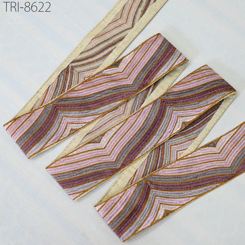 a collection of decorative fabric pieces with a striped pattern in shades of pink, purple, and beige.