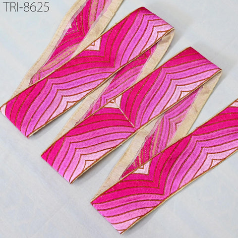 a collection of pink and gold embroidered fabric pieces arranged in a row, with a beige border.