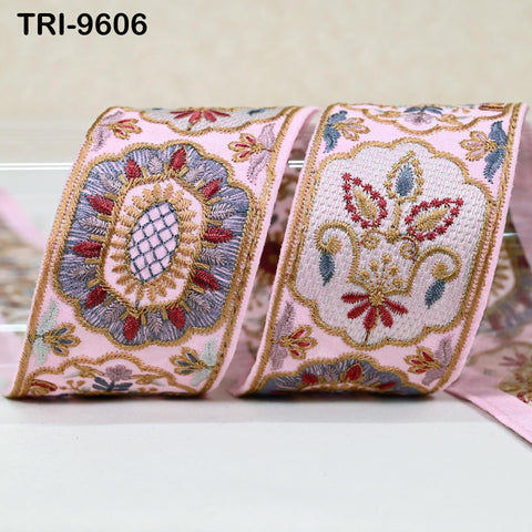 two decorative fabric pieces with intricate embroidered patterns in shades of pink, blue, and gold.