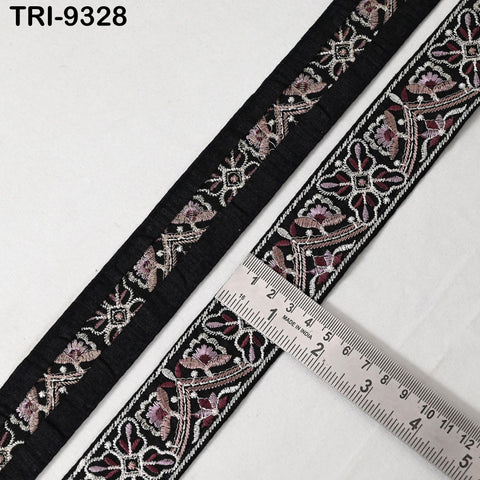 a close-up view of a decorative black and white fabric with intricate floral patterns. A ruler is placed next to the fabric, indicating the size of the fabric.