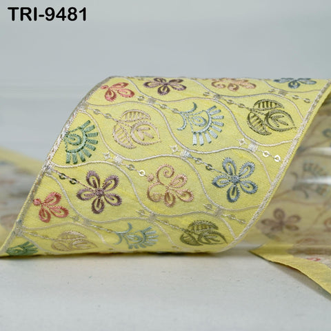 a yellow fabric with a floral pattern, featuring various colored flowers and leaves.