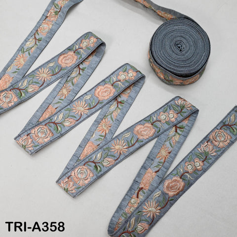 a collection of gray and blue embroidered fabric pieces arranged on a white background.