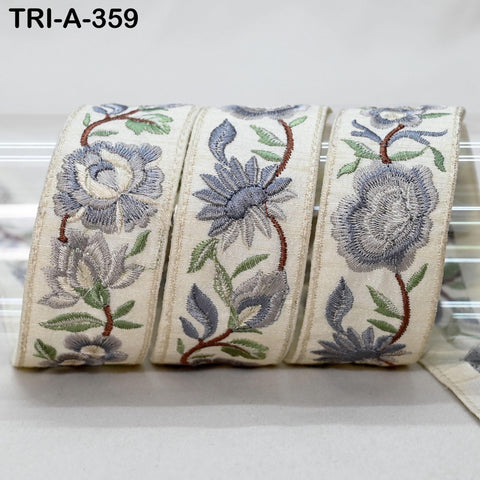A set of three decorative fabric pieces with floral embroidery, arranged in a row.