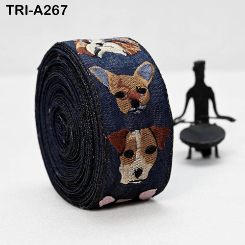 A blue ribbon with embroidered images of dogs on it, along with a small black figure in the background.