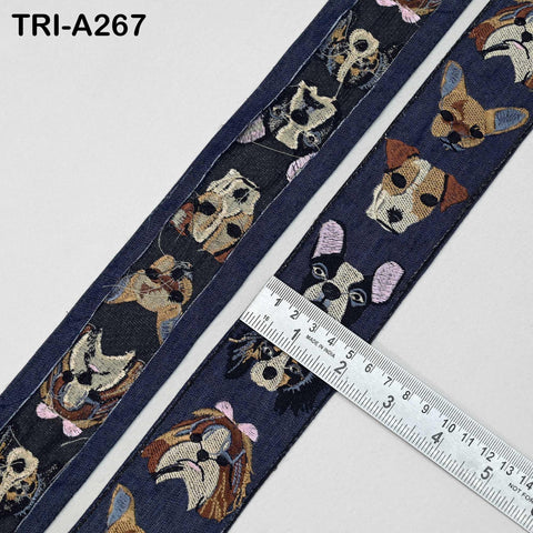 a close-up view of a blue fabric with a repeating pattern of dog faces, including various breeds and colors. A ruler is placed next to the fabric, indicating the size or length of the fabric.