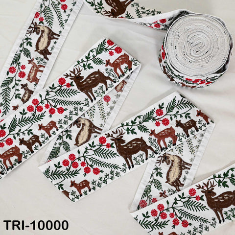 a collection of fabric pieces with a repeating pattern of deer and flowers, including a roll of fabric with the same pattern.