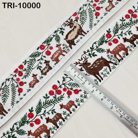 a decorative fabric with a repeating pattern of deer and flowers. The fabric is white and has a floral and leafy design. A ruler is placed on the fabric, indicating its size.