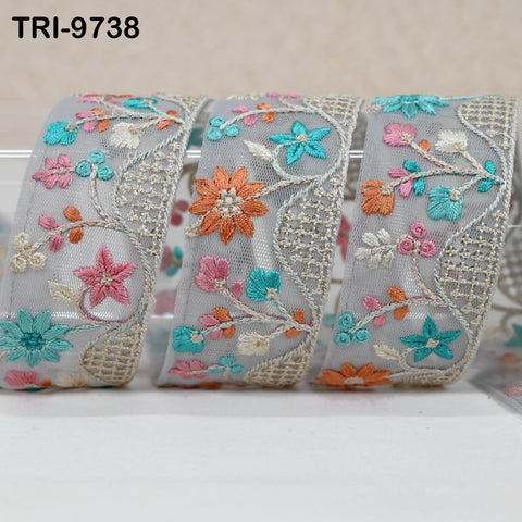 three decorative fabric pieces with intricate floral embroidery in various pastel colors, including shades of blue, pink, and orange.