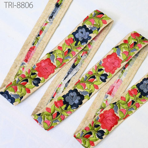 a close-up view of a decorative fabric with a floral pattern in shades of red, green, and blue. The fabric appears to be a beige material with a floral design, and it is arranged in a zigzag pattern.