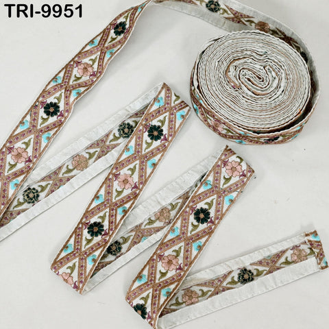 a collection of decorative fabric pieces, including a spool of fabric with a floral pattern and several individual pieces of fabric with a similar floral design.