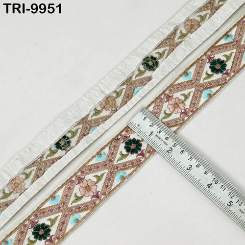 a decorative fabric with a floral pattern and a ruler placed on top of it, indicating the size of the fabric.