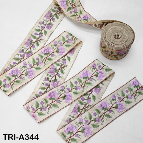 a collection of decorative fabric pieces with a floral pattern, including a spool of thread and several pieces of fabric with the same floral design.