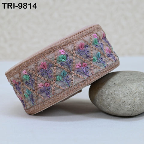 a decorative fabric with a floral pattern, placed on a white surface next to a rock.