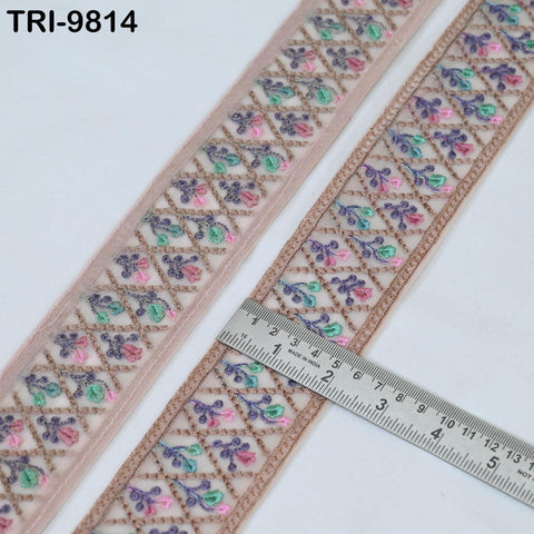 two pieces of fabric with a decorative floral pattern, and a ruler is placed on top of one of the pieces to measure its length.