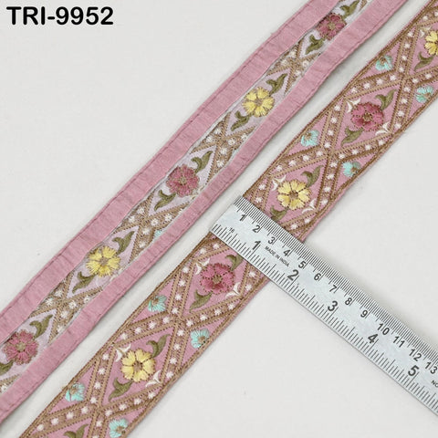 a close-up view of a decorative border with pink and yellow floral patterns, and a ruler is placed next to it to measure the border.