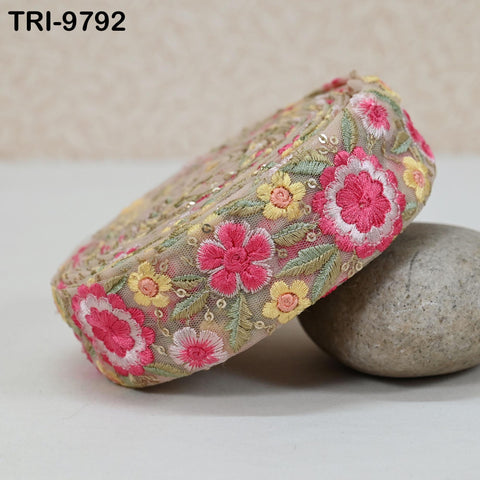 a decorative fabric with a floral pattern, including pink and yellow flowers, placed on a white surface.
