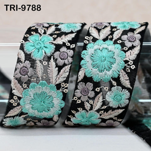 two decorative fabric pieces with a floral pattern in shades of black, white, and turquoise.