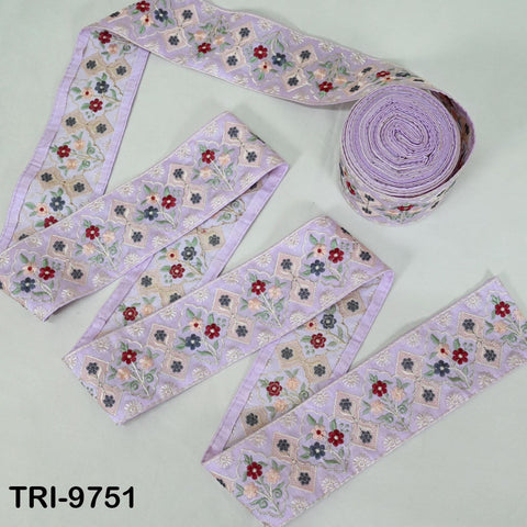 a collection of purple fabric ribbons with floral patterns, including a rolled-up spool of the same ribbons.