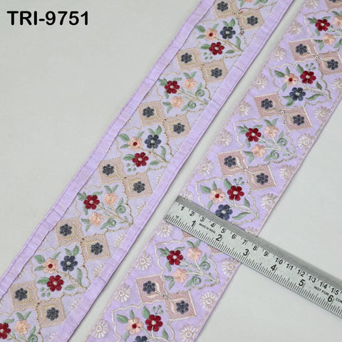 a close-up view of a decorative fabric with a floral pattern, featuring a ruler for scale.