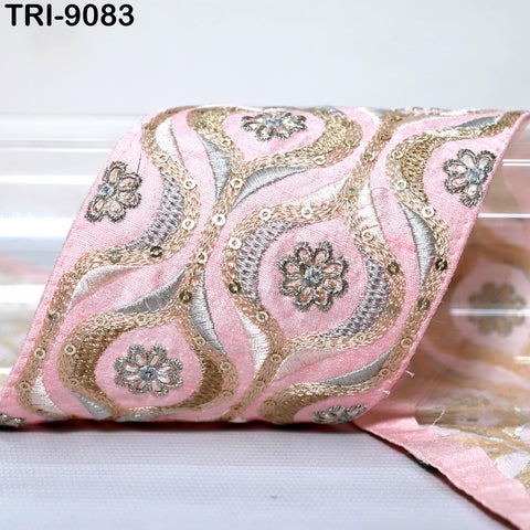 a close-up view of a decorative fabric with a pink and gold floral pattern.