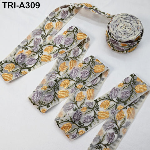 a collection of fabric pieces with a floral pattern, including a spool of thread with a similar design.