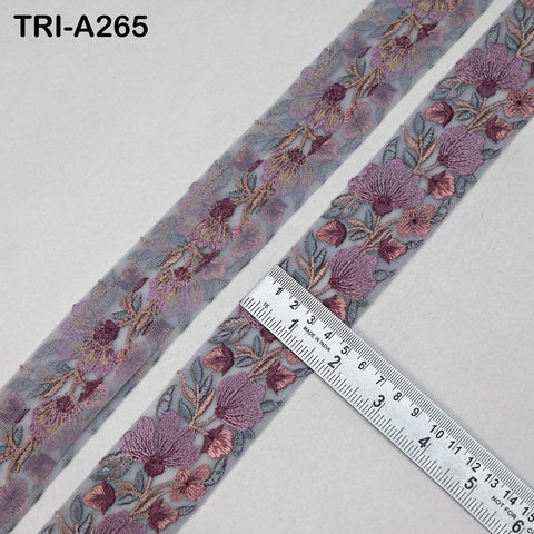a close-up view of a decorative fabric with a floral pattern, featuring a ruler placed on top of it.