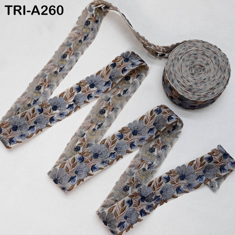 a roll of decorative fabric with a floral pattern, and there is a spool of the same fabric next to it.