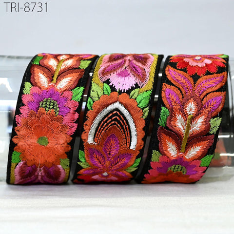 three colorful, intricately embroidered fabric pieces, each with a unique floral design.