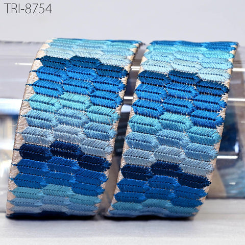 two blue and white patterned fabric rolls or bands, with a repeating geometric design in shades of blue and white.