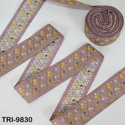 a collection of decorative fabric pieces, including a spool of thread with a floral pattern and several pieces of fabric with a similar floral design.