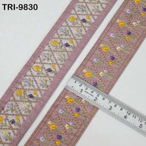a decorative fabric with a floral pattern, and a ruler is placed on top of it to measure the length of the fabric.