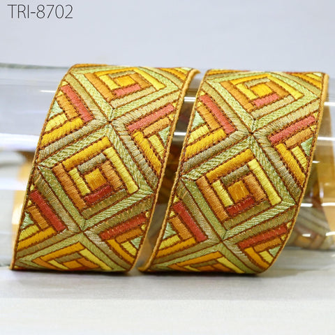 two decorative fabric pieces with a geometric pattern in shades of yellow, orange, and green.