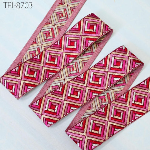 a collection of colorful, patterned fabric pieces, including a pink and red geometric design, arranged on a white background.