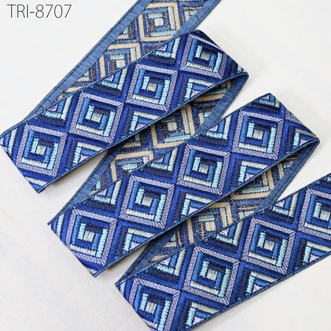 a close-up view of a blue and white geometric patterned fabric, possibly a ribbon or decorative trim.