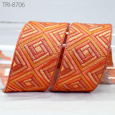 two pieces of orange and gold embroidered fabric, possibly a decorative piece or a textile product.