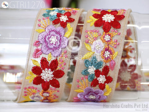 two decorative fabric pieces with colorful floral embroidery.