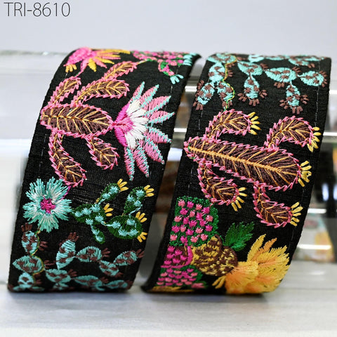 two decorative headbands with intricate embroidered patterns, including flowers and cacti, in various colors such as black, pink, green, and yellow.