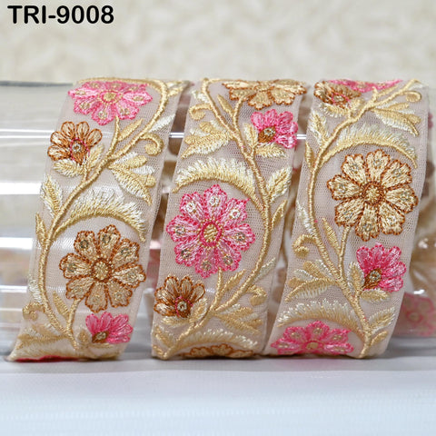 a close-up view of a decorative fabric with a floral pattern, featuring pink and gold flowers and leaves.