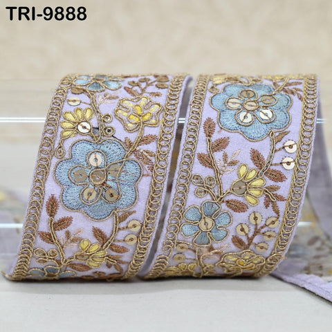 a decorative fabric with a floral pattern in shades of blue and gold. The fabric appears to be a ribbon or a piece of cloth with a floral motif.