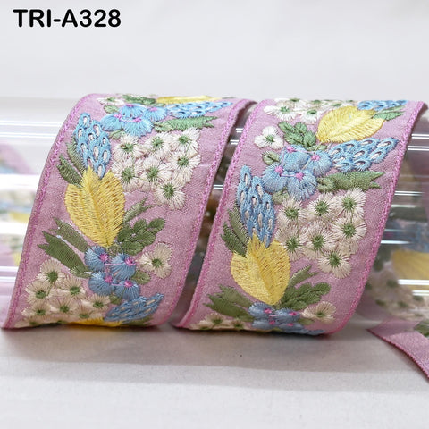 a close-up view of a decorative fabric with a floral pattern, featuring pink, yellow, and blue colors.