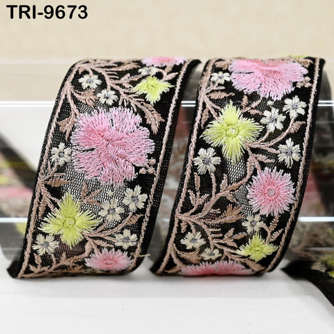 two decorative fabric pieces with intricate floral embroidery in shades of pink, yellow, and green. The pieces appear to be black with a floral pattern, and they are placed side by side on a white surface.