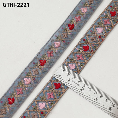 a decorative fabric with a floral pattern, and a ruler is placed next to it to measure the length of the fabric.