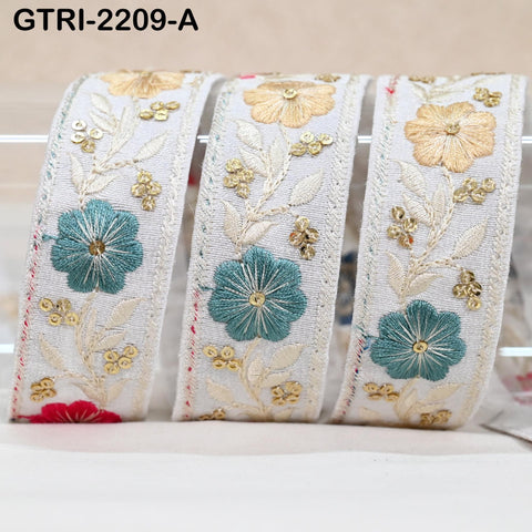 Three decorative fabric pieces with intricate floral embroidery in shades of white, gold, and blue.