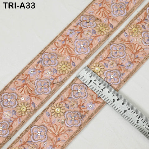 a decorative fabric with a floral pattern, featuring a ruler placed on it to measure its length.