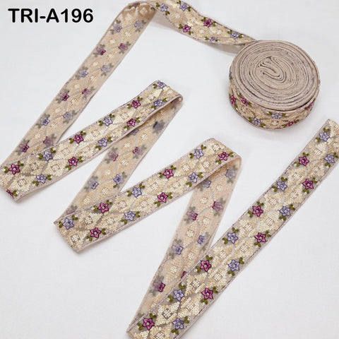 a collection of decorative fabric pieces, including a spool of beige fabric with a floral pattern and several pieces of fabric with a similar floral pattern.