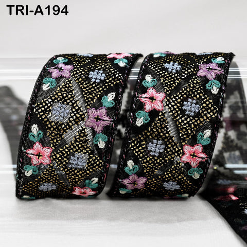 two decorative fabric pieces with a floral pattern, featuring a mix of pink, purple, and green flowers against a black background.